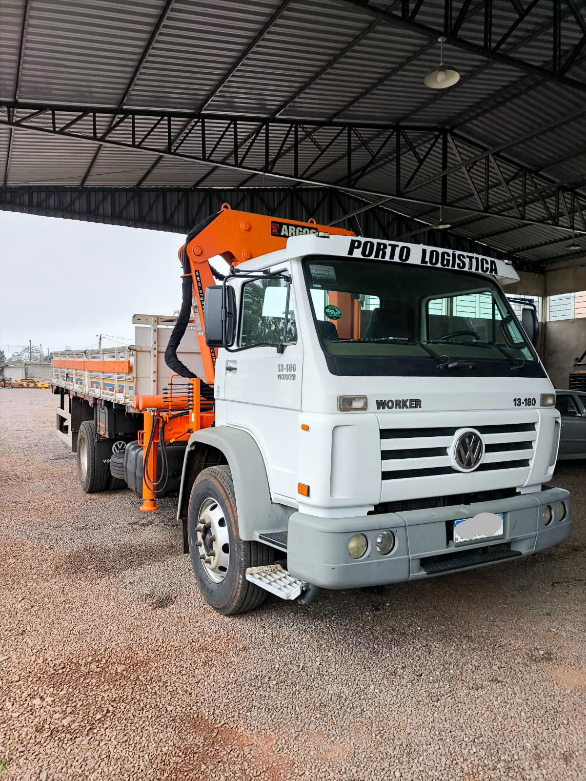 Detalhe do caminhão munck Porto Logística com guindaste articulado Argos laranja